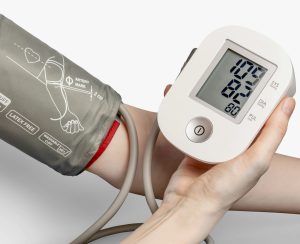 A person using a blood pressure monitor. Do health conditions really benefit from exercise?